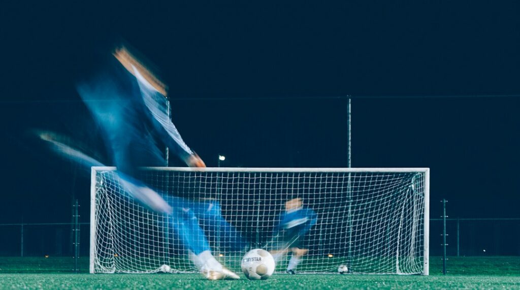 Player shooting at goal as the goalkeeper dives