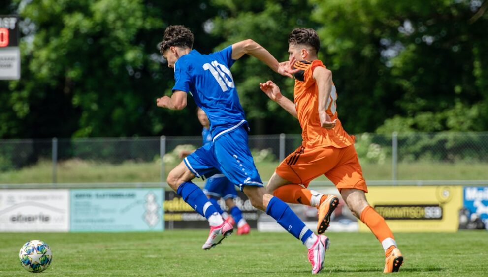 Footballer running across the pitch in position