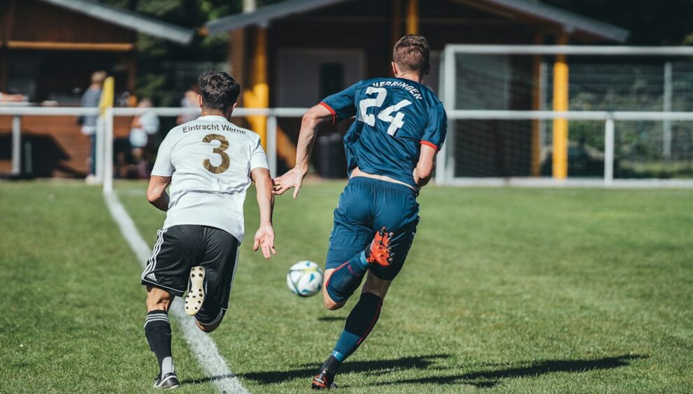 Two footballers competing for the ball