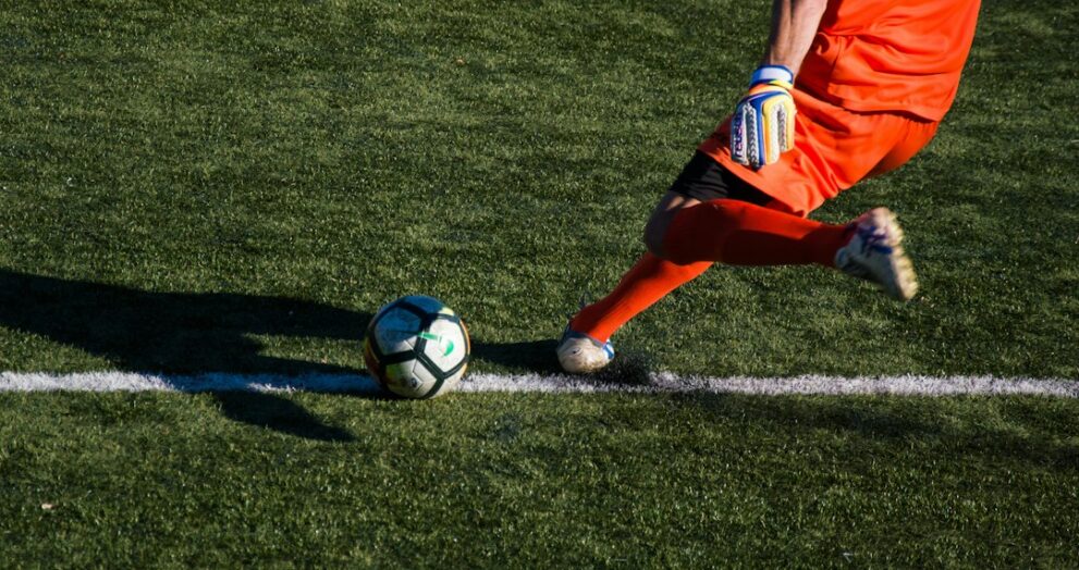 Football match with players and the referee on the pitch