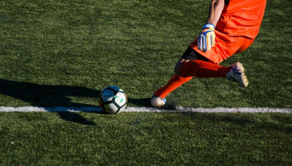 Football match with players and the referee on the pitch
