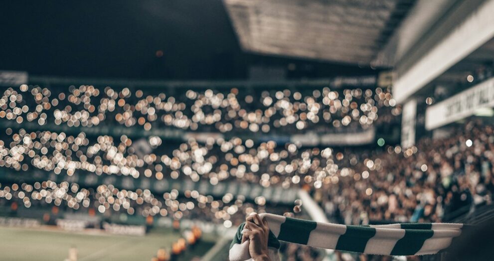 Fan holding up a football shirt in the stands